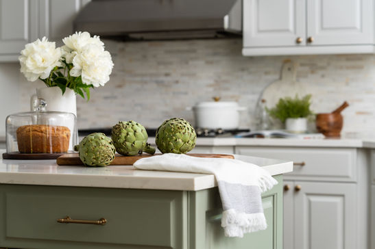 Kitchen design with green island, quartz countertops, cream cabinetry, and tile backsplash created by Design Studio Detroit for a luxury new build project.