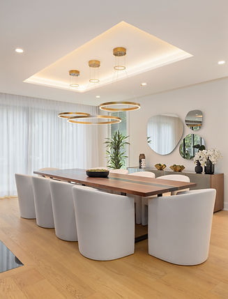 Contemporary-modern dining room designed by Anastasia Mitrovic Interiors featuring a long wood table, modern white chairs, sculptural pendant lighting, and layered styling in a luxury Greenwich, Connecticut home.