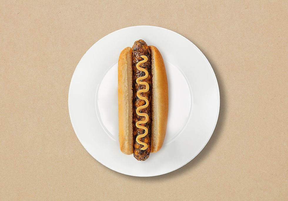 Fotografía profesional de alimentos para IKEA: hot dog con mostaza servido en plato blanco sobre fondo neutro