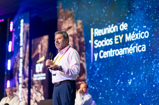 Ponente de EY presentando en el escenario durante la reunión de socios de EY México y Centroamérica en Los Cabos, parte de la cobertura de fotografía y video corporativo profesional de Fotos para Empresas.