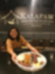 Kalapaw owner serving Kamayan feast tray in front of logo on wall