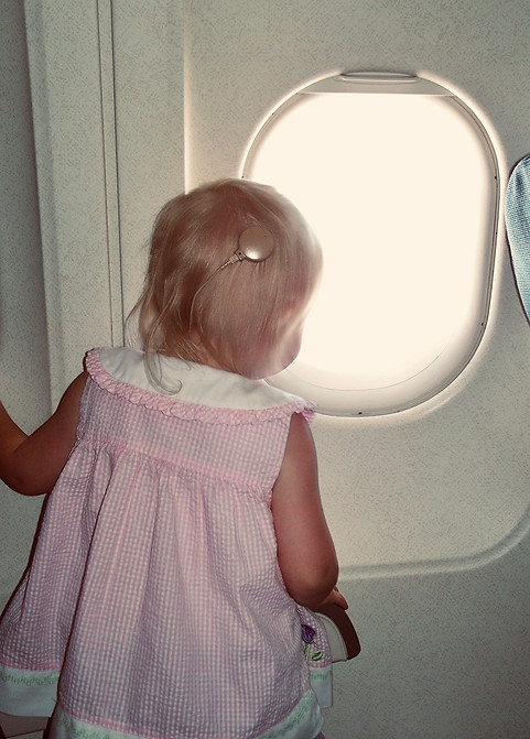Baby with Advanced Bionics Cochlear Implants looking out airplane window