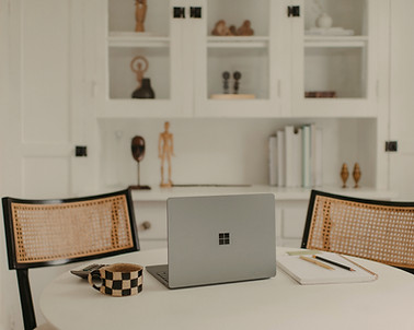 Online therapy set up with clean, modern kitchen background with a laptop open on a desk