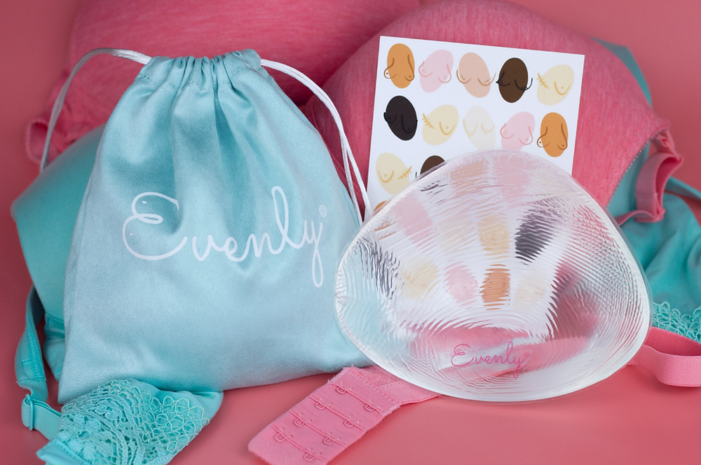 A silicone Evenly Bra Balancer (a non-surgical solution to uneven boobs) sits next to an exclusive blue storage bag.