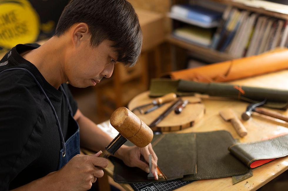 eye-level view of leather strips and tools on wooden table
