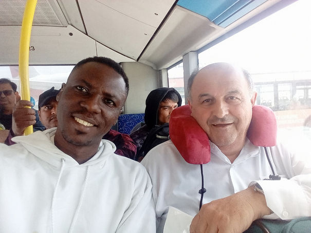 Two smiling men on a bus