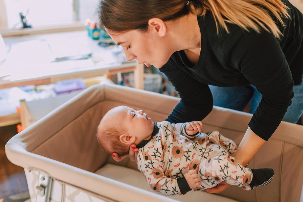Mother gently placing her baby to sleep while singing a soothing lullaby — singing and humming as a calming technique for newborns