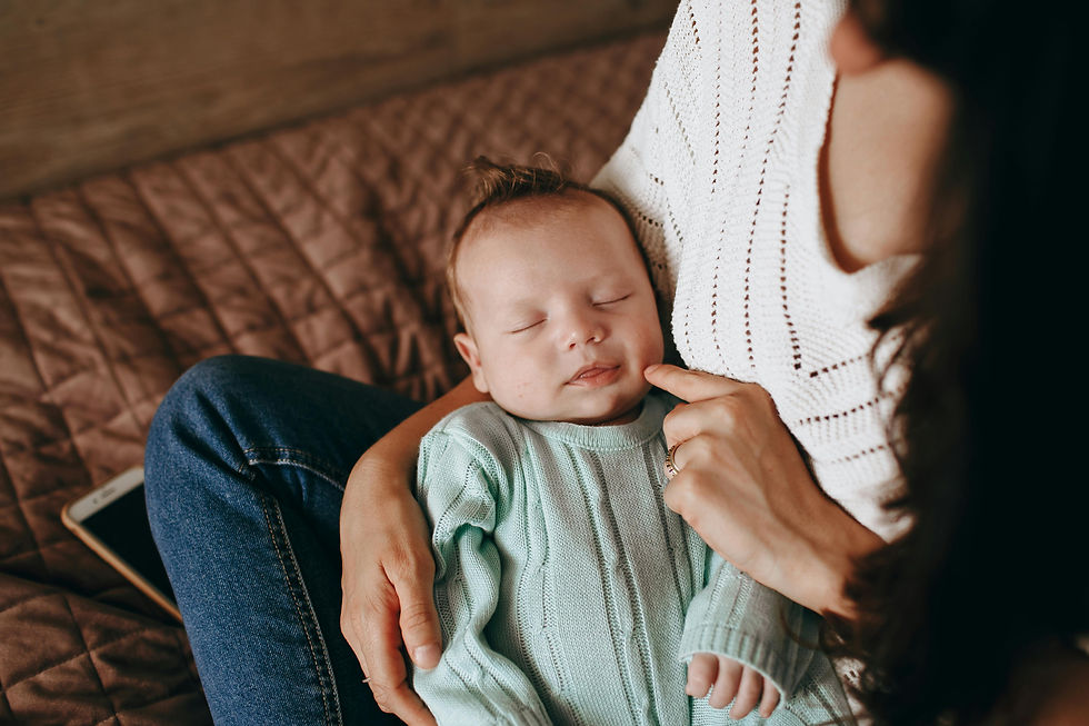 Newborn baby sleeping peacefully in mother's lap — gentle parenting moment