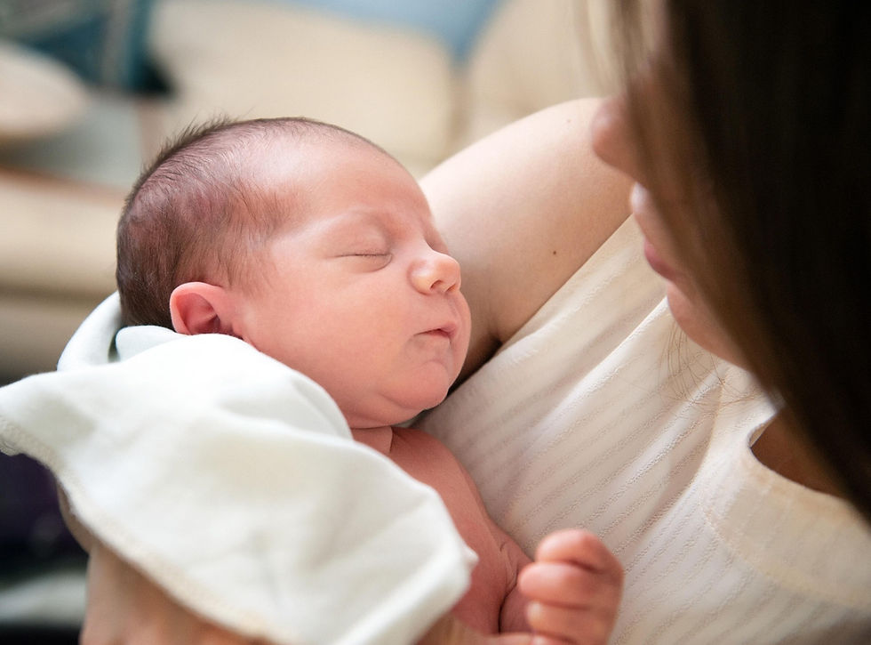 Mother tenderly holding her sleeping newborn — peaceful bedtime moment for babies and parents