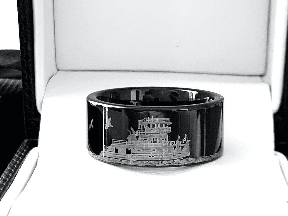 Thumbnail: Men’s tungsten carbide wedding band with a detailed towboat and river scene engraving.