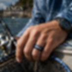 Men wearing blue Wahoo fish engraved tungsten ring on ring finger in a fisherman inspired boat setting