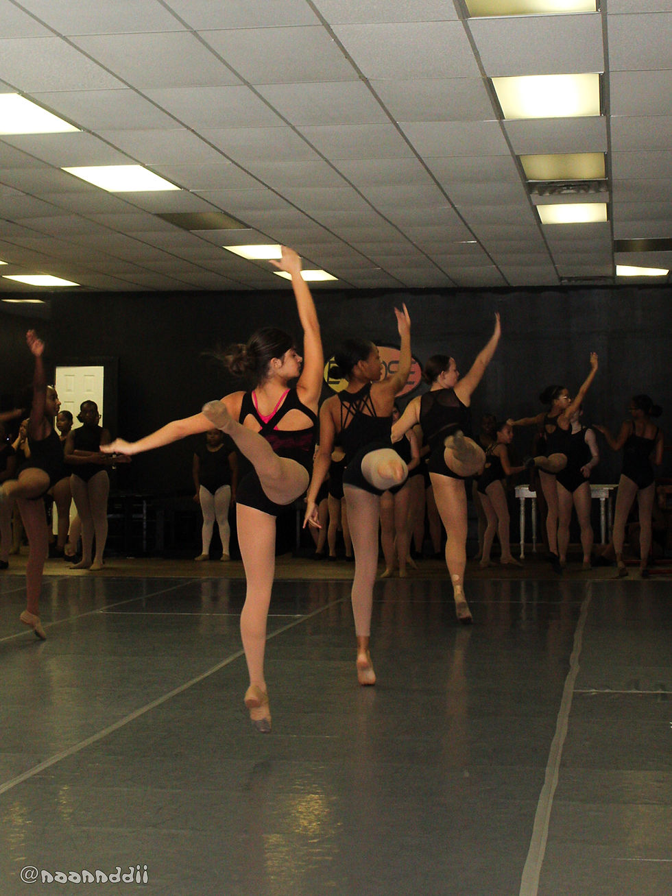 Eye-level view of a dancer practicing choreography in a spacious studio