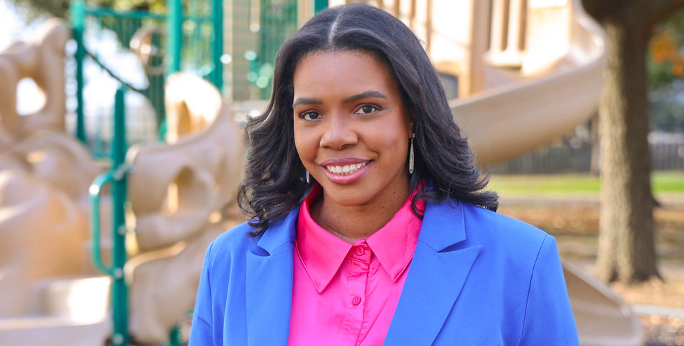 Tiffany Auzenne Asonye is running for Katy ISD and is pictured in a blue suit and pink shirt which are her campaign colors in front of a playground to represent students and community.