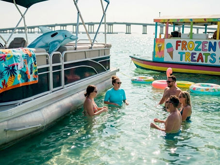 People relaxing by boat at Crab Island sandbar