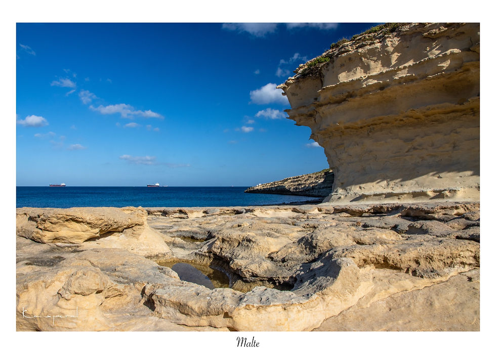 Roche creusée par l'érosion au pied de hautes falaises en calcaire à Malte