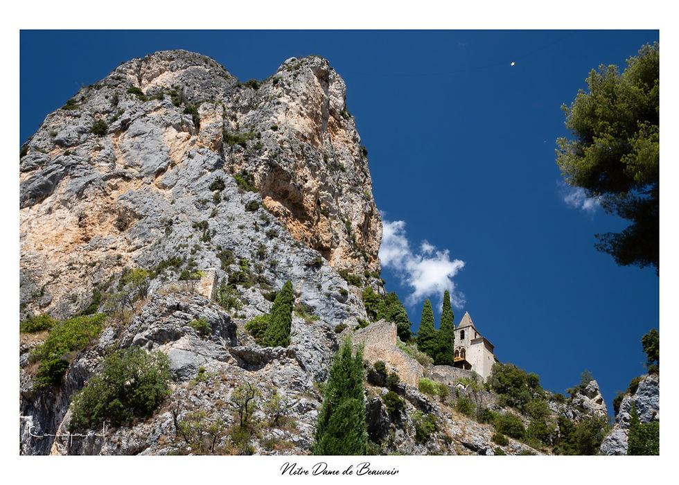 Petite chapelle perchée au sommet de hautes falaises au dessus d'un village des Alpes de Haute-Provence