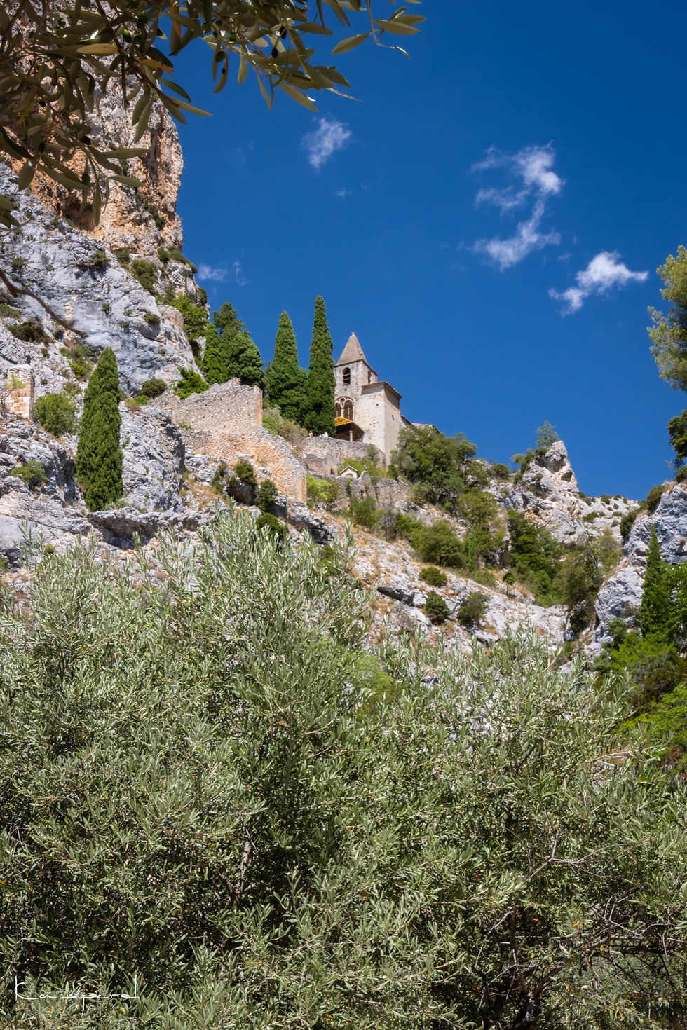 Miniature : Chapelle perchée sur une falaise au pied de laquelle poussent des oliviers
