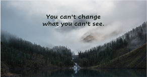 Mountain peak emerging through fog over forest lake representing awareness and clarity