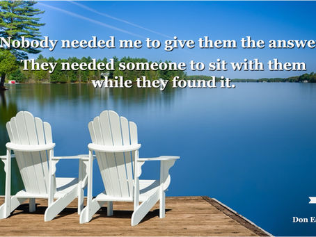 Two white Adirondack chairs side by side on a wooden dock overlooking a calm lake surrounded by trees. Text reads: "Nobody needed me to give them the answer. They needed someone to sit with them while they found it." Don Eash Coaching logo in bottom right corner.