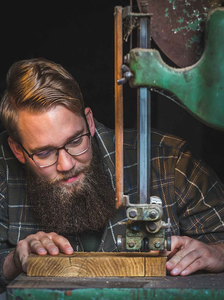 Bärtiger Mann sägt Holz