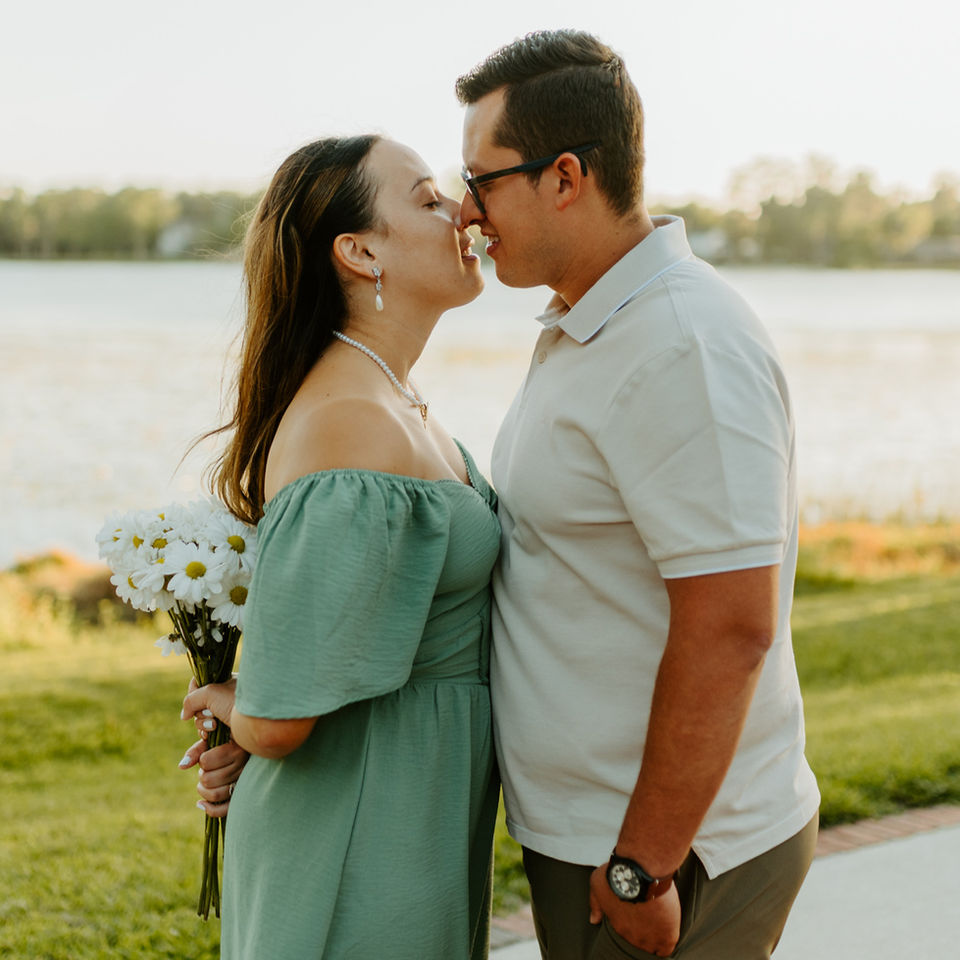 Couple holding flowers and and intimate moment during their engagement photo session in Madrid, Spain.