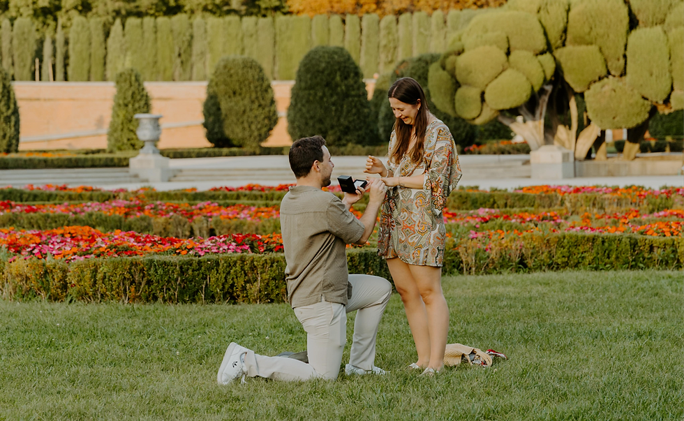 Couple getting engaged at Retiro Park Garden surrounded by flowers.