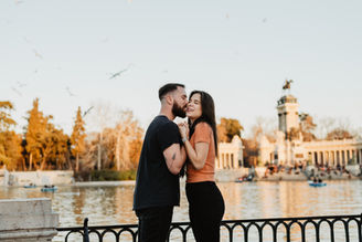 Couple sharing a fun moment in front of the Retiro Lake during their couple session in Madrid