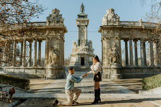 Hombre se arrodilla pidiendo matrimonio a su novia en el parque del Retiro mientras ella se emociona.