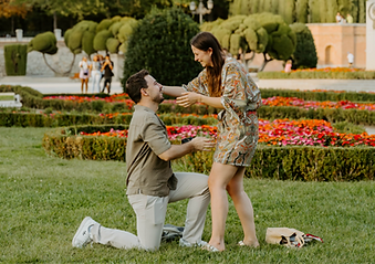 Couple share a happy moment after secret proposal at Parterre Gardens in Retiro park during summer.