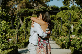 Emotional reaction from bride-to-be during a surprise proposal in El Retiro Park.