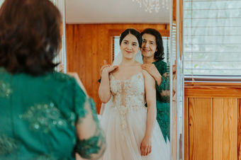 Bride looking at herself in the mirror with her mother before wedding in Madrid.