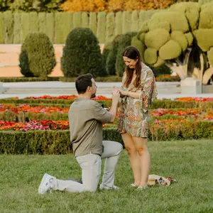 Man placing a ring on his now fiancée's finger during Parterre Gardens proposal
