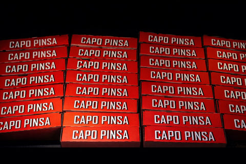 Stacked Capo Pinsa takeaway boxes showcasing the bold branded packaging in Zürich.