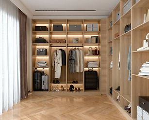 A modern walk-in closet with clothes, shoes, and luggage neatly arranged — a beautifully decluttered space that feels calm and functional.