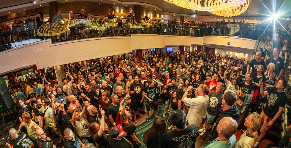 large crowd on two level indoor concert venue with bright lights