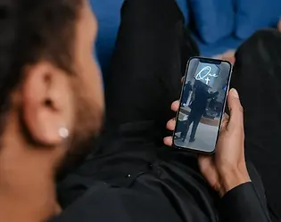 Image of man watching the live stream on his phone. 