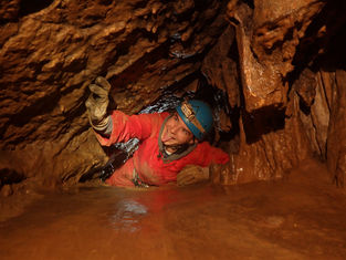 Passage en ramping dans le parcours du combattant en spéléologie