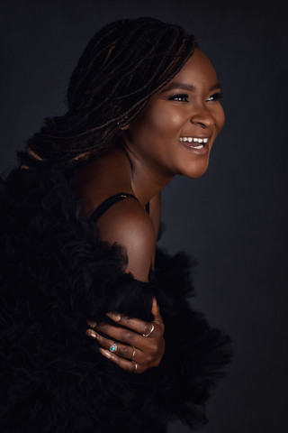 african american woman smiling in front of black backdrop