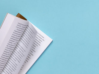 Photo by Stas Knop on Pexels of a partially opened book on a blue background.