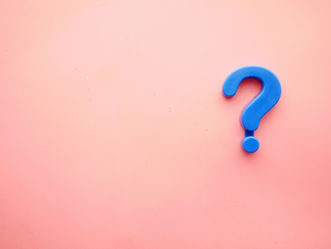 Photo by Towfiqu barbhuiya on Unsplash of a teal question mark on a pink surface.