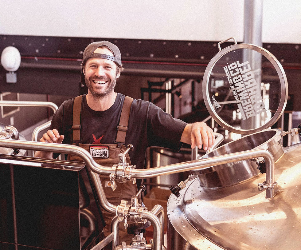 photo of man in apron smiling while running a brewery