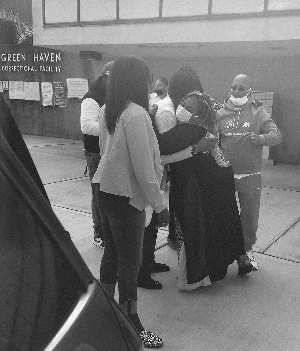 Woman and man hugging at a correctional facility.