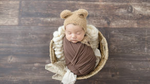 swaddled newborn with bear hat in the studio
