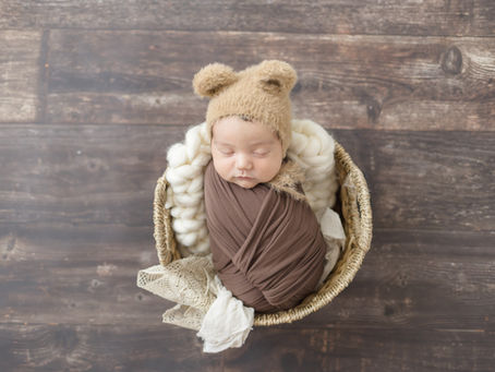 swaddled newborn with bear hat in the studio