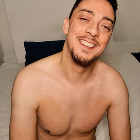 A male yoni massage therapist, naked and smiling.