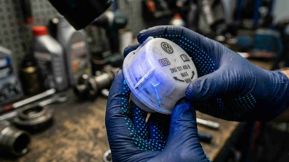 hands-only macro of cracked VW coolant reservoir cap under UV light