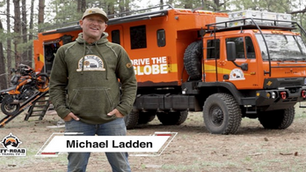 a man posing with a large expedition rig