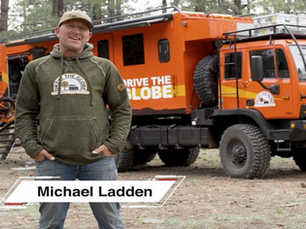 a man posing with a large expedition rig