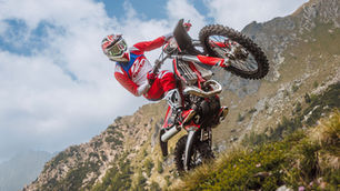 A rider doing a wheelie up a steep slope