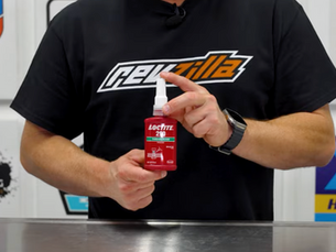 a man holding a bottle of Loctite Thredalocker Red